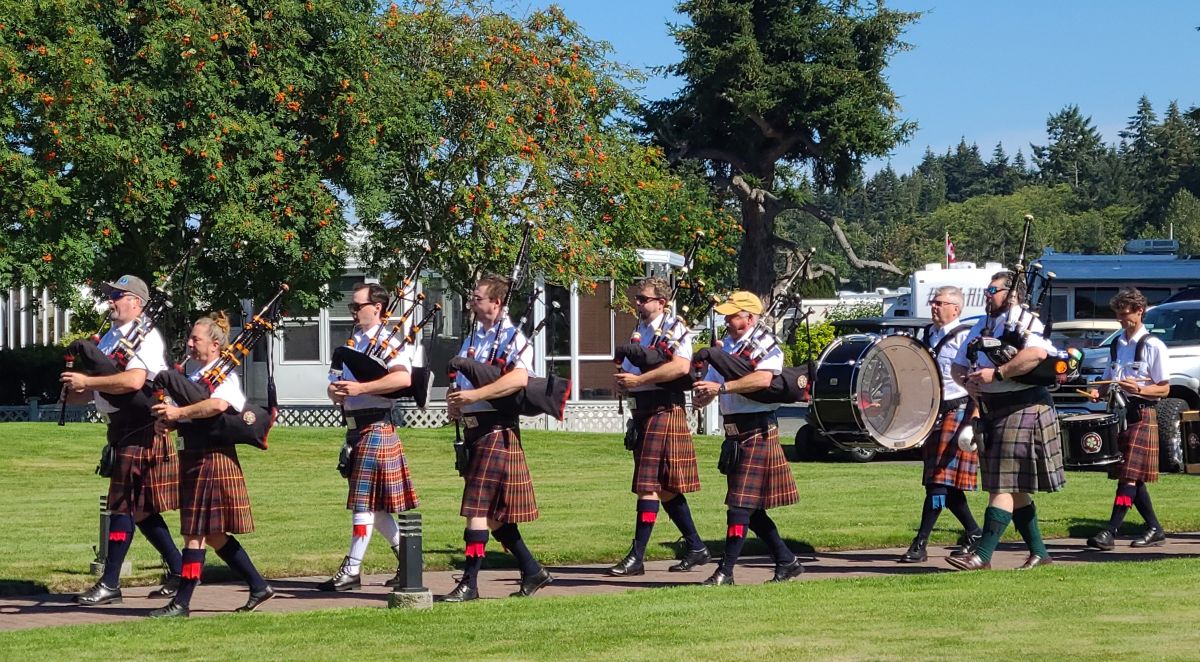 a pipe and drum band walking down a pathway